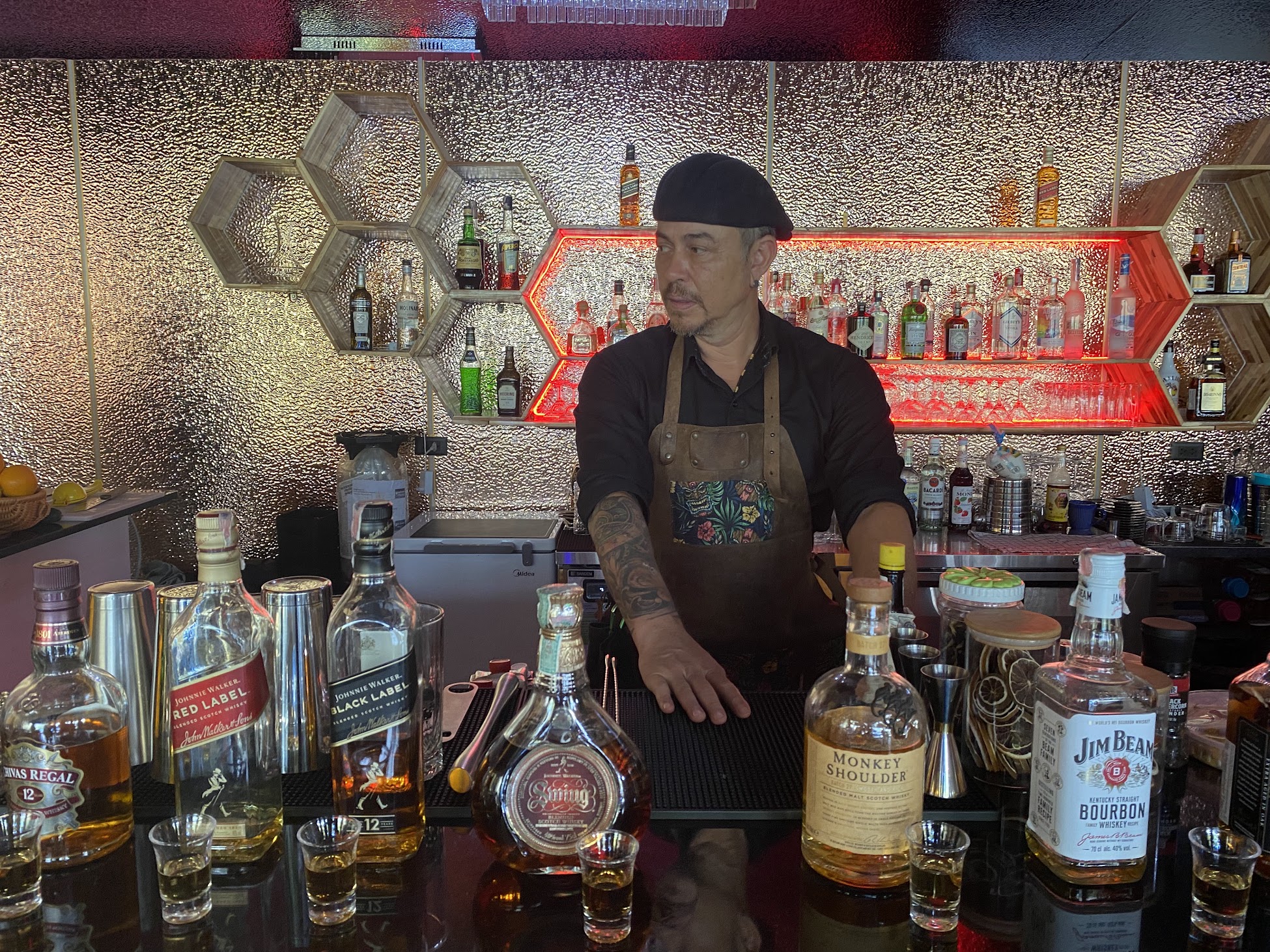 Bartender training boosts revenue through faster service. A bartender instructor is showing the students different spirits.